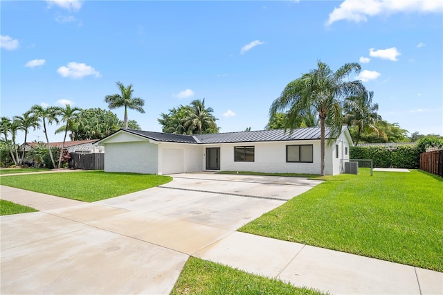 ranch-style home with a garage, central AC, and a front lawn