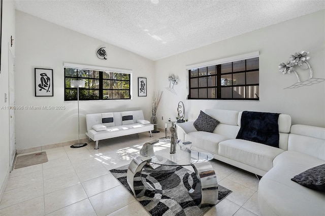 living room featuring lofted ceiling, a textured ceiling, and light tile patterned flooring