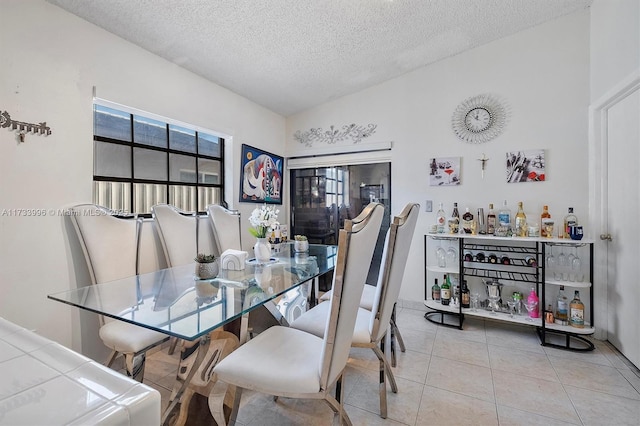 tiled dining space with a textured ceiling