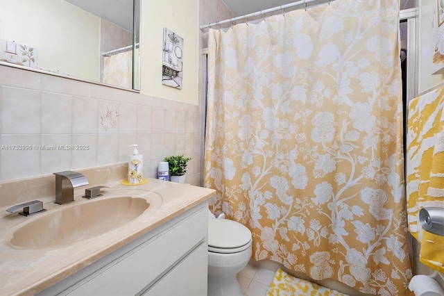 bathroom featuring tile patterned flooring, vanity, tile walls, and toilet