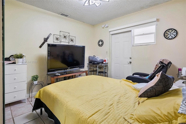 bedroom with light tile patterned flooring and a textured ceiling