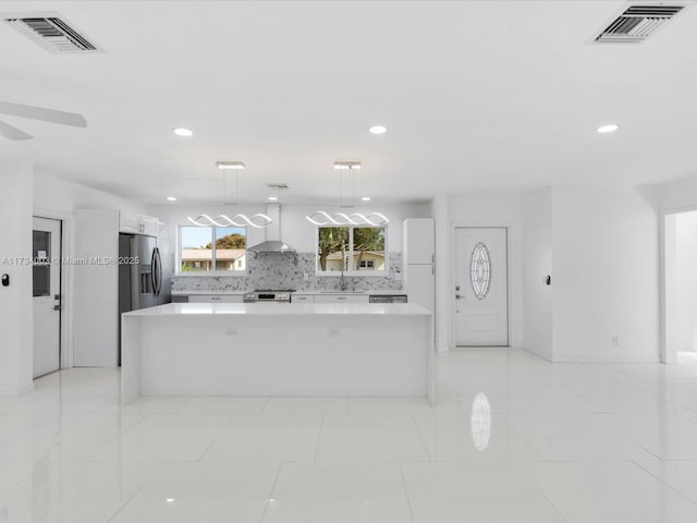 kitchen with sink, a center island, pendant lighting, stainless steel appliances, and white cabinets