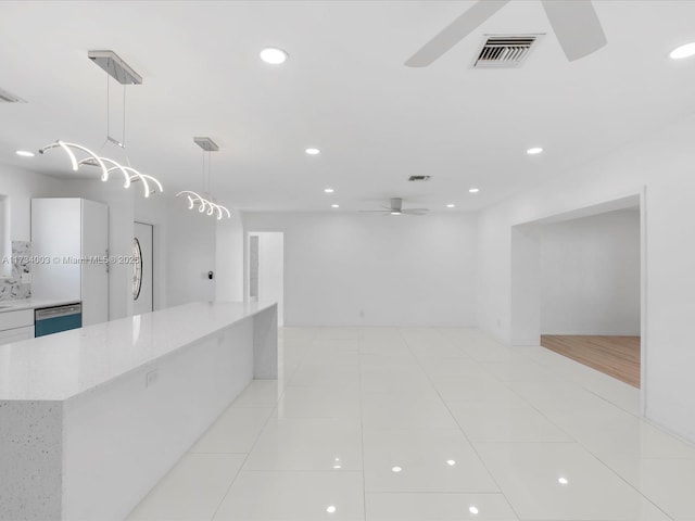 kitchen featuring ceiling fan, dishwasher, light stone countertops, light tile patterned flooring, and decorative light fixtures