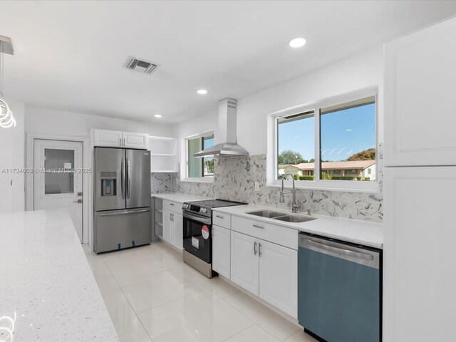 kitchen with sink, white cabinetry, island range hood, stainless steel appliances, and decorative backsplash