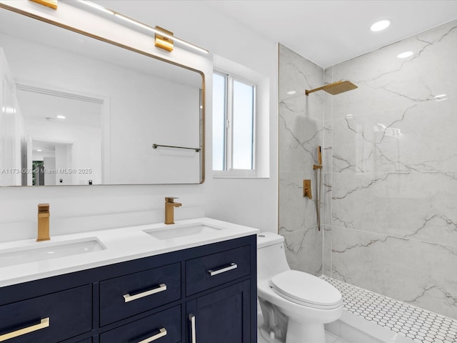 bathroom featuring vanity, a tile shower, and toilet