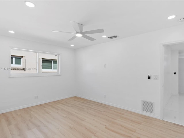 spare room with ceiling fan and light wood-type flooring