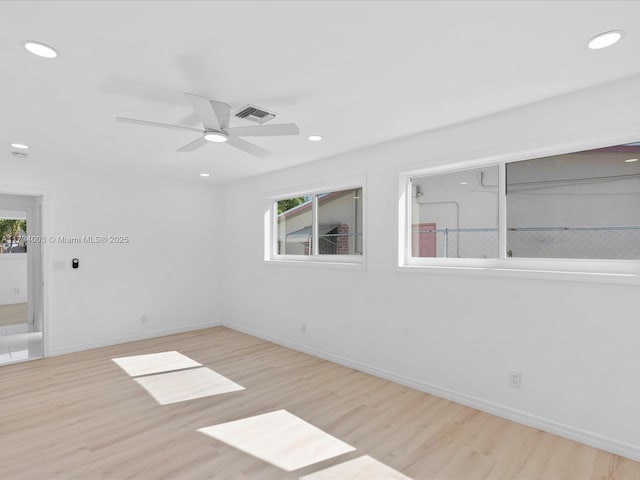 spare room with ceiling fan, light hardwood / wood-style floors, and a healthy amount of sunlight