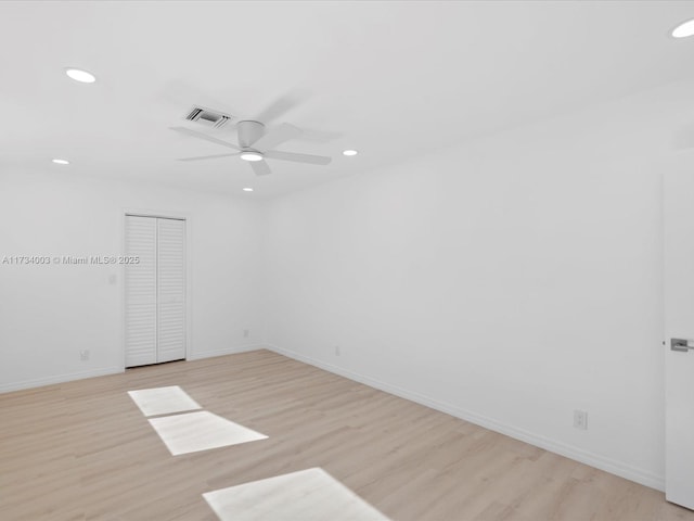 spare room with ceiling fan and light wood-type flooring