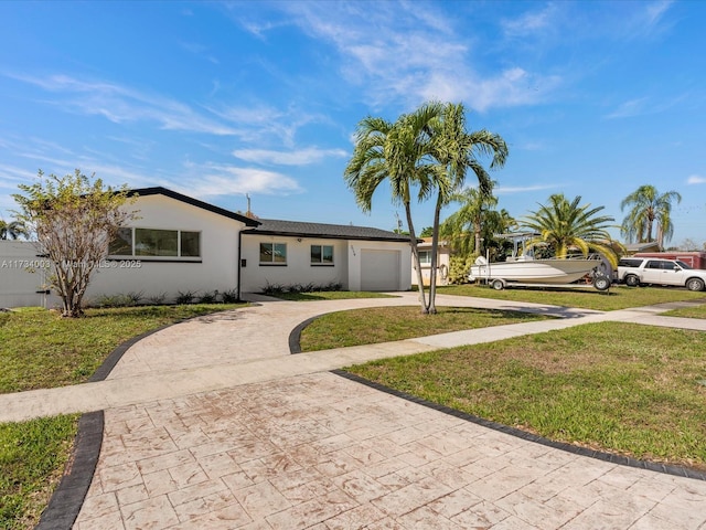 ranch-style house featuring a garage and a front lawn