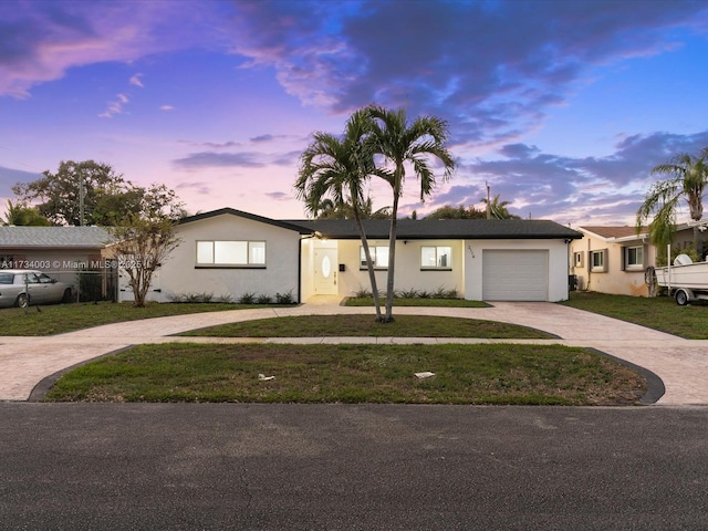 single story home with a garage and a yard