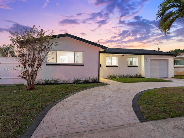 view of front of house featuring a garage and a lawn