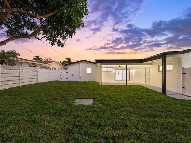 yard at dusk featuring a patio area