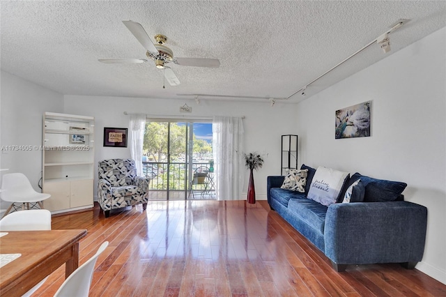 living room featuring hardwood / wood-style floors, track lighting, a textured ceiling, and ceiling fan