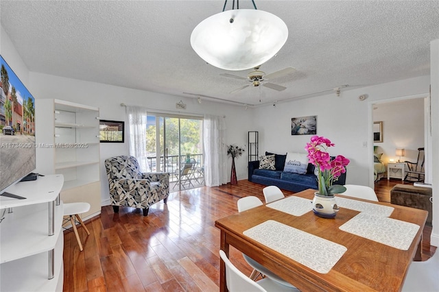 dining area with hardwood / wood-style floors, a textured ceiling, and ceiling fan