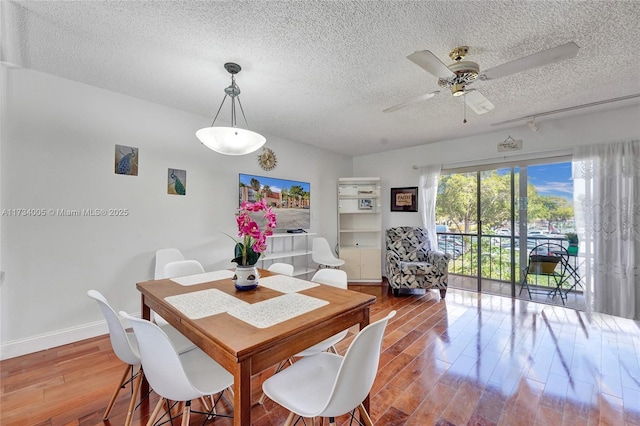 dining space featuring ceiling fan, hardwood / wood-style floors, and a textured ceiling