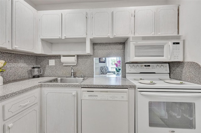 kitchen with white cabinetry, white appliances, sink, and tasteful backsplash