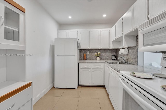 kitchen featuring light tile patterned flooring, sink, white cabinetry, white appliances, and decorative backsplash