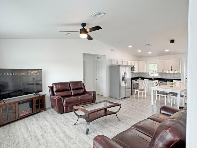 living room featuring vaulted ceiling, sink, ceiling fan, and light hardwood / wood-style floors