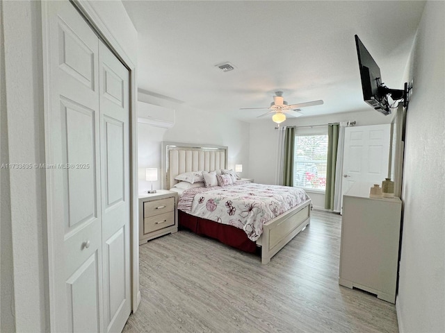 bedroom featuring ceiling fan, a closet, and light wood-type flooring