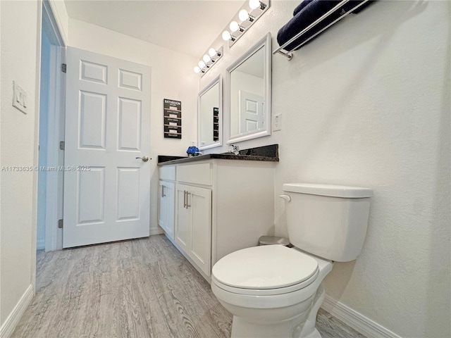 bathroom featuring hardwood / wood-style flooring, vanity, and toilet