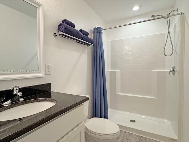 bathroom with vanity, hardwood / wood-style floors, curtained shower, and toilet