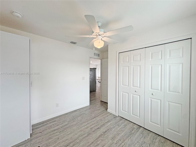 unfurnished bedroom with a closet, ceiling fan, and light wood-type flooring