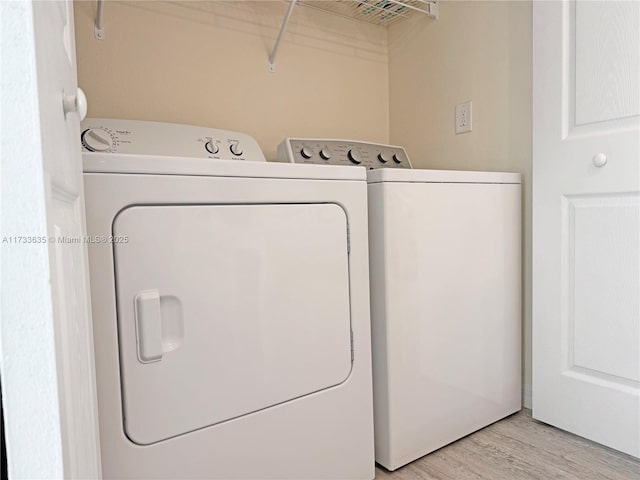 washroom featuring washing machine and dryer and light wood-type flooring