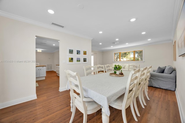 dining space with ornamental molding and dark wood-type flooring