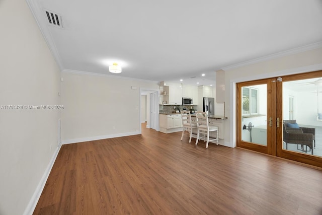 unfurnished living room with french doors, crown molding, and light hardwood / wood-style flooring