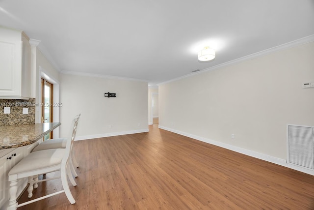 interior space featuring crown molding and light hardwood / wood-style floors