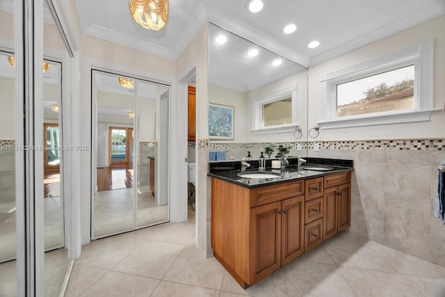 bathroom featuring crown molding, tile patterned flooring, tile walls, vanity, and toilet