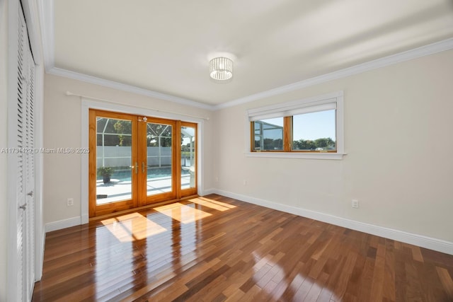 spare room featuring wood-type flooring, crown molding, and french doors