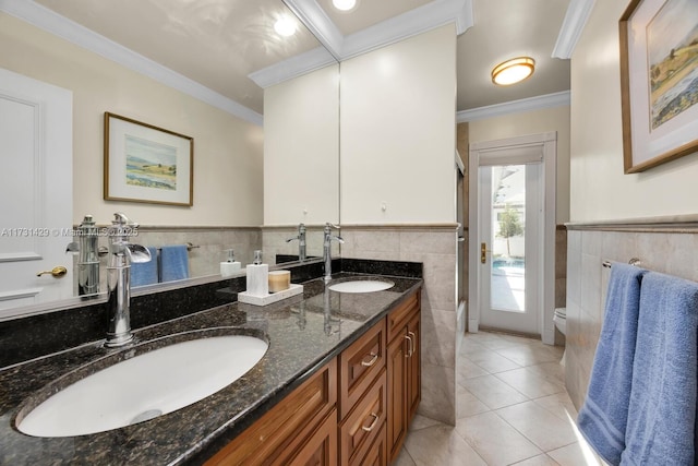 bathroom featuring tile patterned flooring, tile walls, vanity, ornamental molding, and toilet