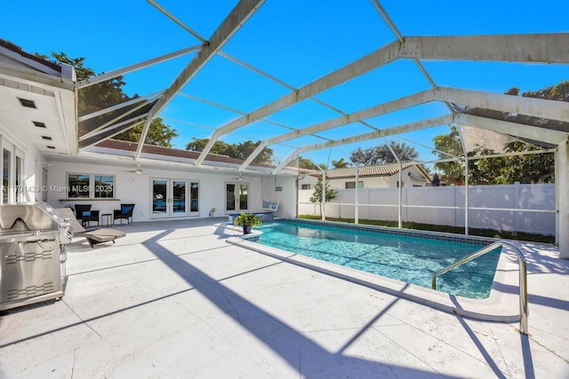 view of pool with french doors, a patio area, a lanai, ceiling fan, and a grill