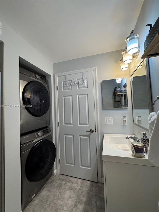 laundry area with stacked washer and clothes dryer, tile patterned flooring, and sink