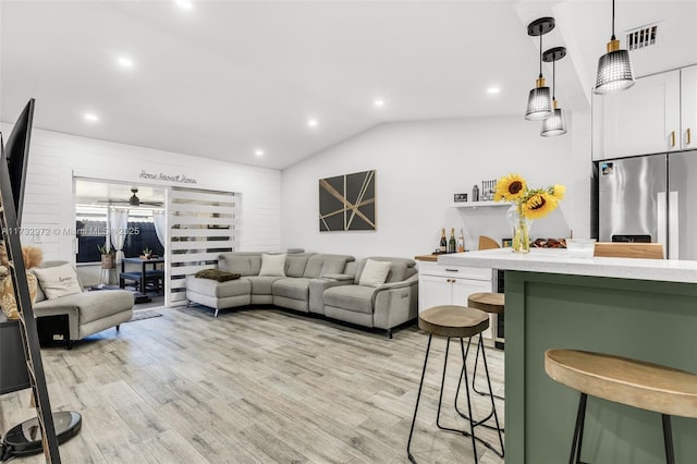 living room with vaulted ceiling and light hardwood / wood-style flooring