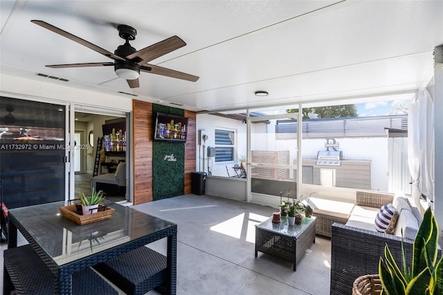 sunroom / solarium featuring ceiling fan