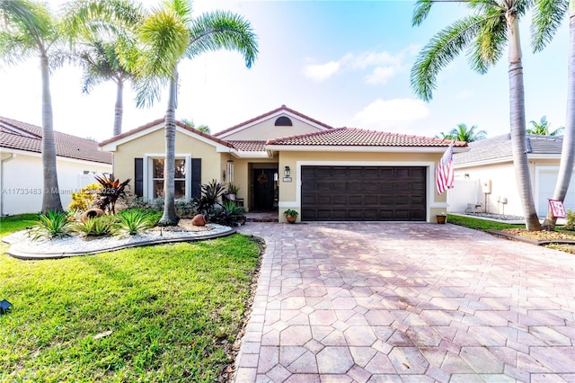 single story home with decorative driveway, a tile roof, stucco siding, an attached garage, and a front yard