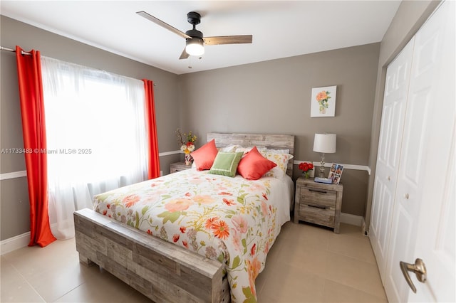 bedroom with a ceiling fan, a closet, baseboards, and light tile patterned floors