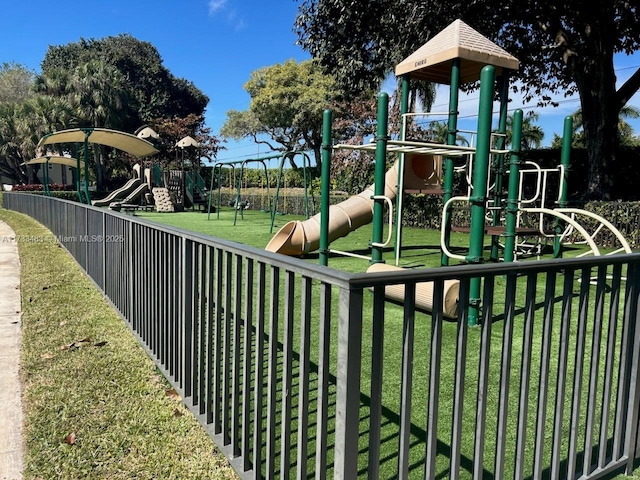 community play area featuring fence and a yard