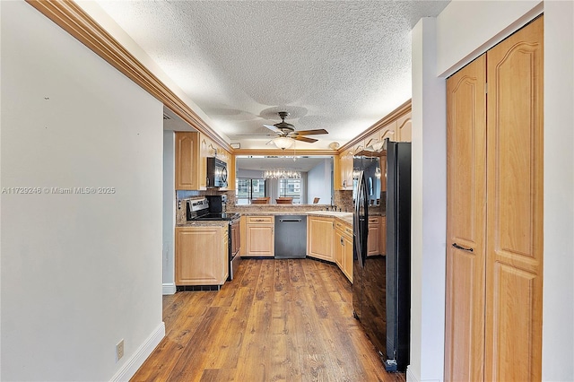 kitchen featuring light brown cabinetry, backsplash, light hardwood / wood-style floors, black appliances, and crown molding