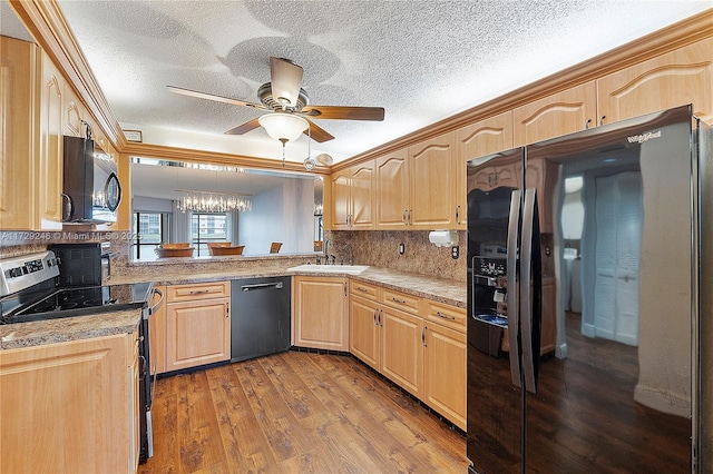 kitchen with hardwood / wood-style floors, light brown cabinetry, tasteful backsplash, sink, and black appliances