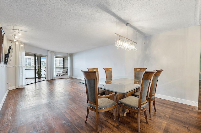 dining area featuring dark wood-type flooring, an inviting chandelier, and a textured ceiling