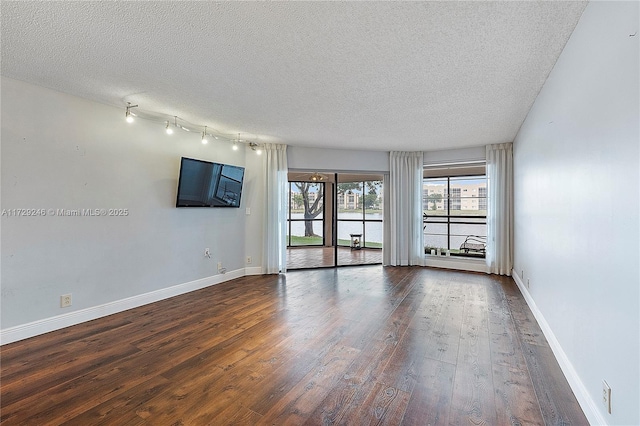 spare room featuring dark hardwood / wood-style floors and a textured ceiling