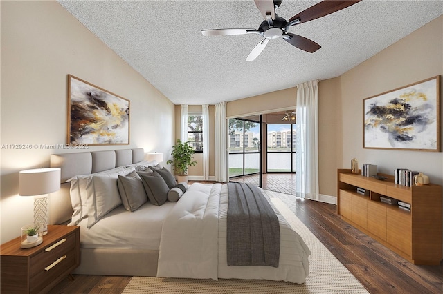 bedroom with a textured ceiling, access to outside, dark hardwood / wood-style floors, and ceiling fan