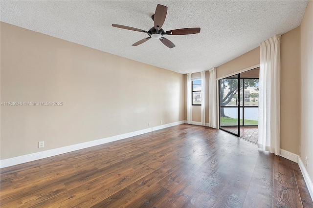 unfurnished room with ceiling fan, dark hardwood / wood-style flooring, and a textured ceiling