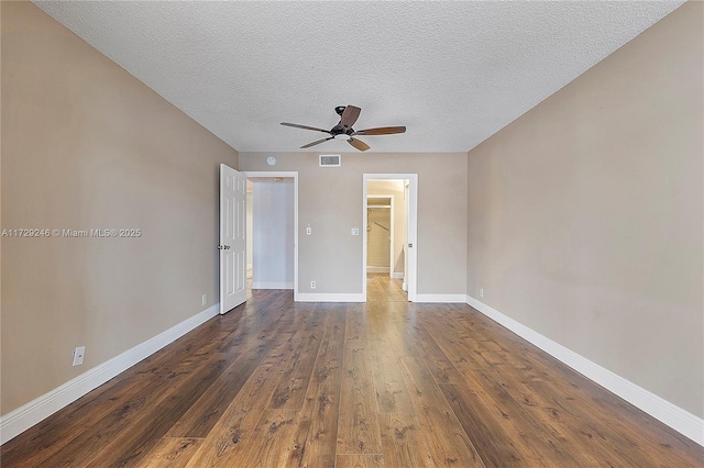 unfurnished room featuring ceiling fan, dark hardwood / wood-style flooring, and a textured ceiling