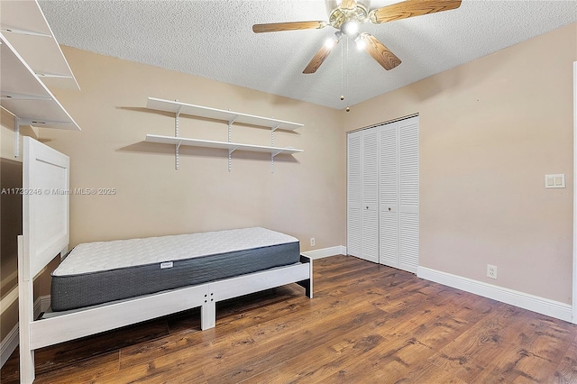 bedroom with hardwood / wood-style flooring, ceiling fan, a closet, and a textured ceiling