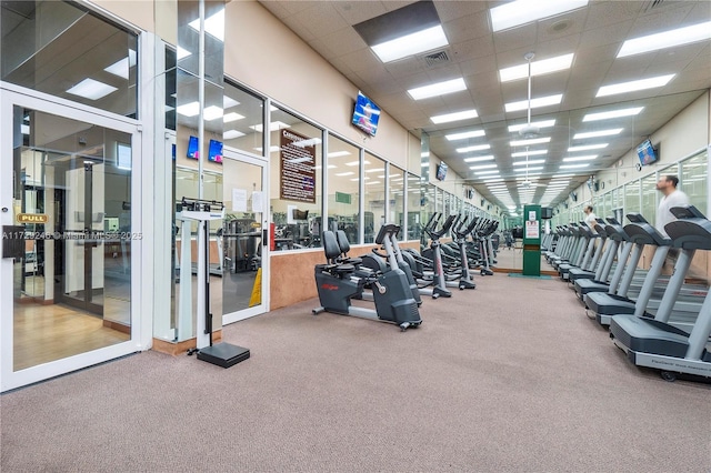 workout area with carpet floors and a drop ceiling