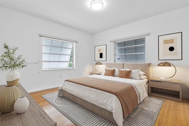 bedroom with light wood finished floors and baseboards